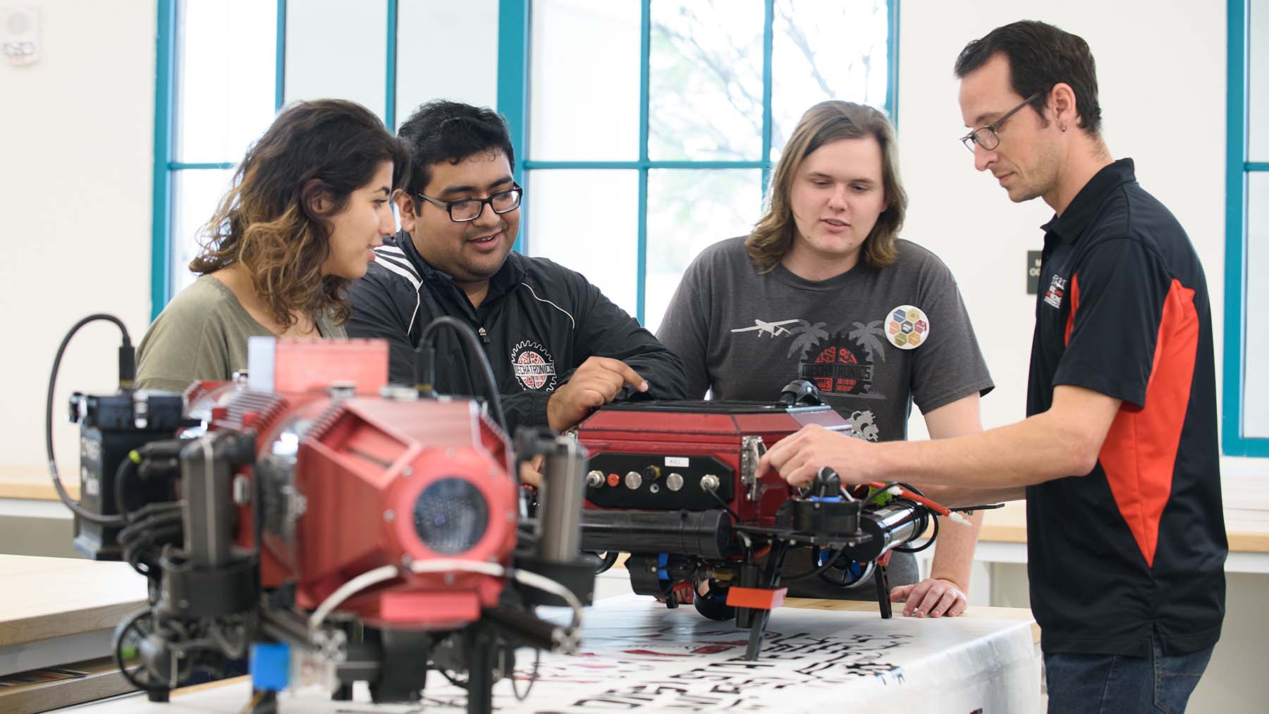 A group of mechanical engineering students working on an engine