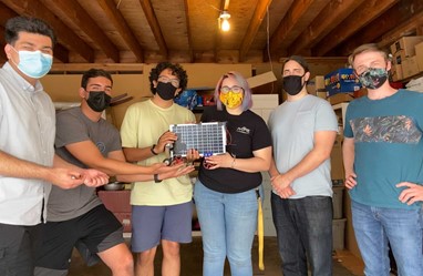 Team holding up a solar powered robot