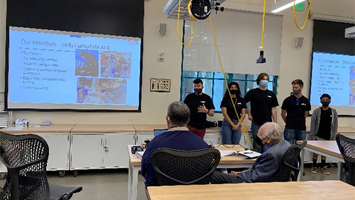 Students presenting their Critical Design Review; Dr. Woodcock with a group of students and Dr. Scott Shaffar, instructor of ME Senior Design