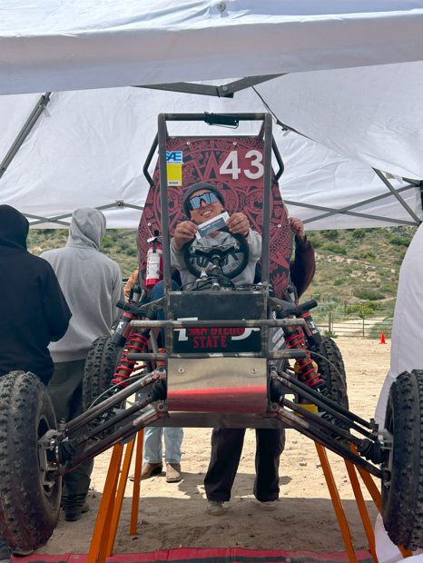 An Aztec Racing student in a car